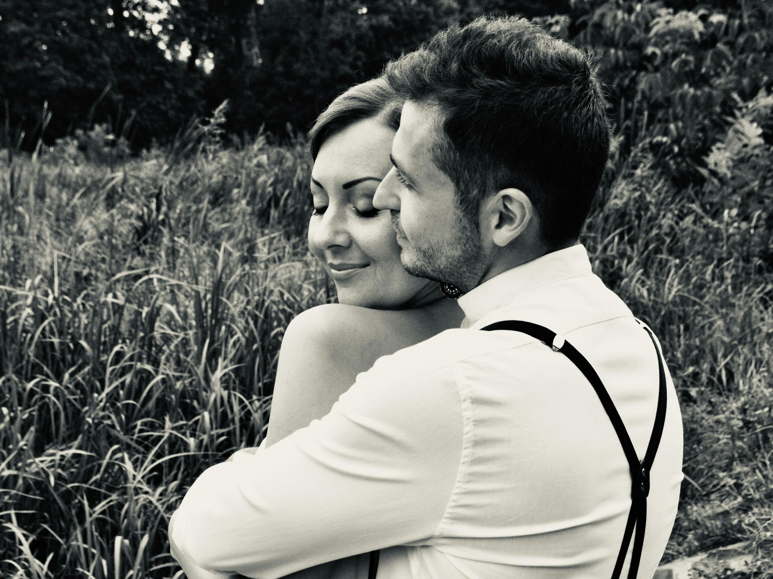 A loving couple embracing in nature, captured in black and white for a timeless feel.