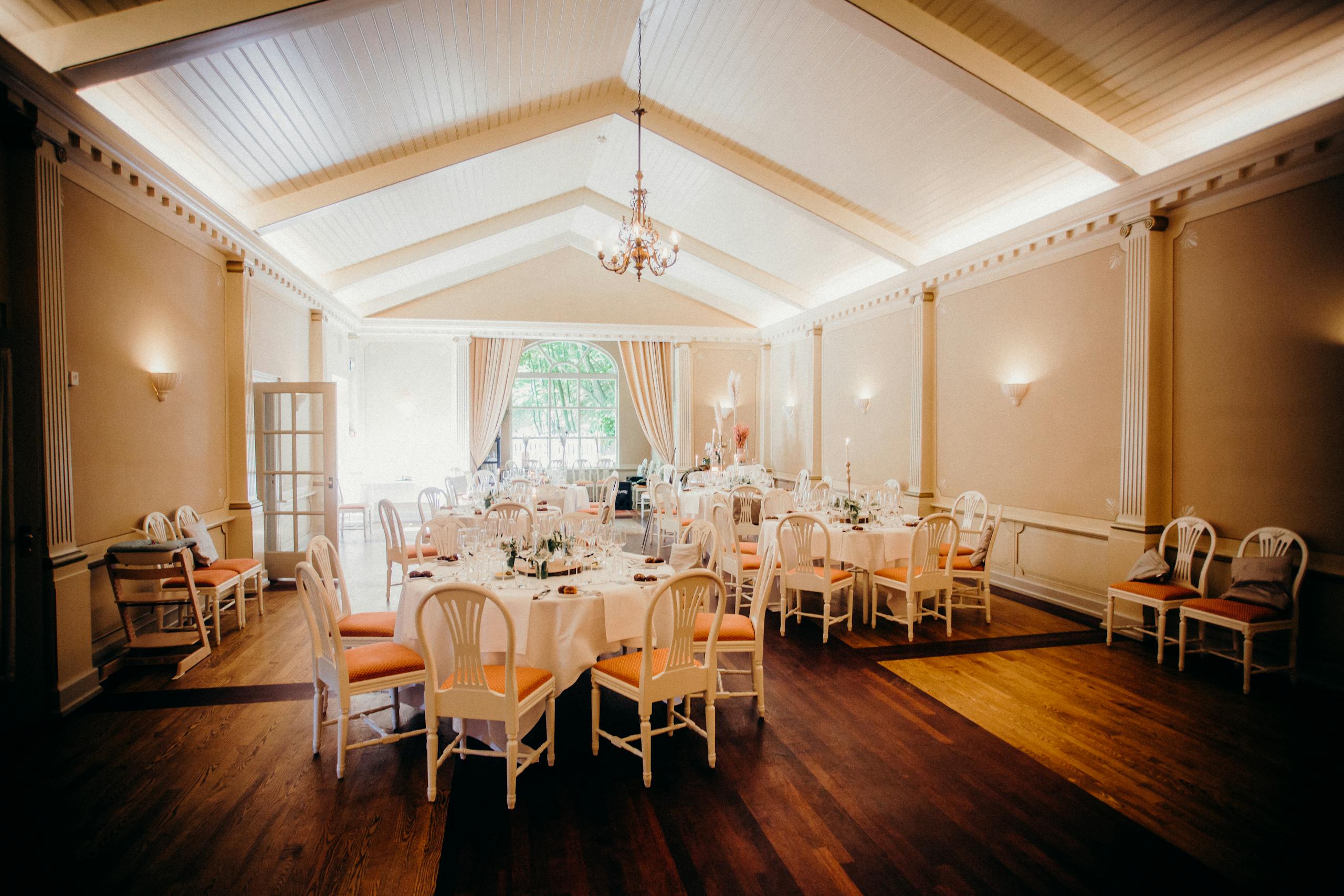 Beautifully decorated wedding reception venue with elegant dining tables and warm lighting.